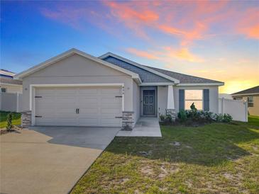 Charming single-story home with a two-car garage, landscaped front yard, and neutral color palette at 456 Hilltop Dr, Lake Wales, FL 33853