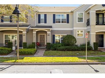 Charming townhome featuring blue shutters, a well-manicured lawn and a welcoming front entrance at 12313 Citruswood Dr, Orlando, FL 32832