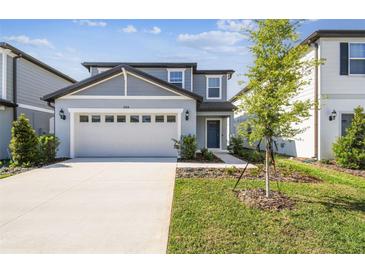 Charming two-story home with a two-car garage, landscaped yard, and a welcoming entrance, perfect for Gathering living at 288 Woodsage Pl, Lake Alfred, FL 33850
