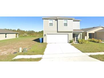 Two-story home featuring a two car garage, well-maintained lawn, and a classic siding exterior at 1753 Eagle Hammock Blvd, Eagle Lake, FL 33839