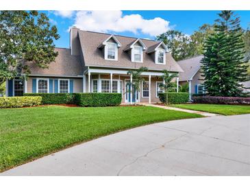 Charming two-story home featuring manicured lawn and manicured hedges, accented with beautiful mature trees at 17416 Magnolia Island Blvd, Clermont, FL 34711