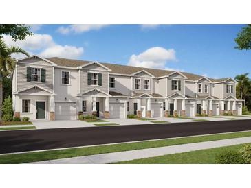 Row of newly constructed townhouses showcasing a uniform design with garages and manicured lawns at 2610 Skyline Loop, Kissimmee, FL 34758