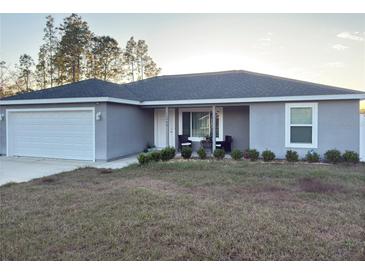 Charming single-story home featuring an attached garage and covered front porch at 15068 Sw 43Rd Ct, Ocala, FL 34473