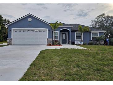 Charming single-story home boasts a well-manicured lawn and a two car garage at 1264 Buckeye Ne Rd, Winter Haven, FL 33881