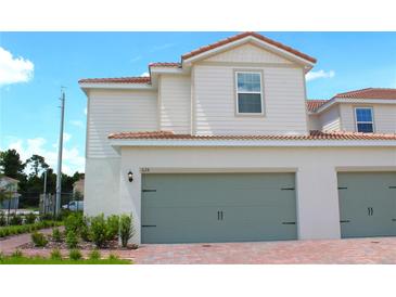 Charming two-story home featuring a two-car garage, red tile roof, neutral siding and a well-manicured front yard at 628 Bay Leaf Dr, Poinciana, FL 34759