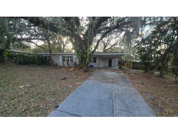 Charming single-story home with a large yard and mature trees covered in Spanish moss at 1804 S Mellonville Ave, Sanford, FL 32771
