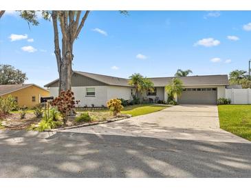 Charming single-story home with a well-maintained lawn and a long driveway leading to a two-car garage at 5029 Sheffield Rd, Lakeland, FL 33813