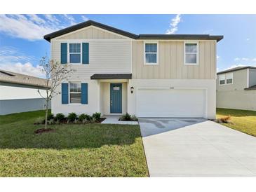 Charming two-story home featuring blue shutters, a well-manicured lawn, and an attached two-car garage at 2122 Rosewood Dr, Bartow, FL 33830