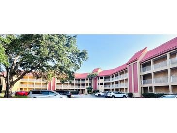 Condominium complex boasts red tile roofs, multiple stories, covered balconies, and ample parking space at 6337 Parc Corniche Dr # 2101, Orlando, FL 32821