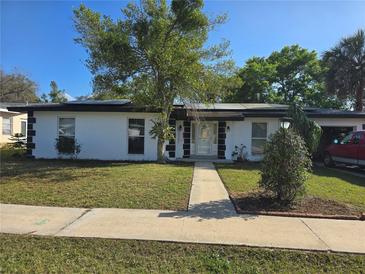 Charming single-story home featuring white walls, dark trim, and a well-maintained front lawn at 663 Hager St, Deltona, FL 32725