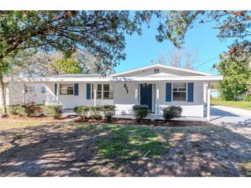 Charming home showcasing blue shutters, manicured bushes, and a well-maintained lawn at 211 W Valencia St, Lakeland, FL 33805