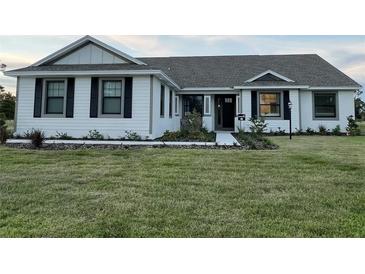 Charming single-story home with white siding, black shutters, and a well-manicured front lawn at 2569 Rogers Rd, Lakeland, FL 33812