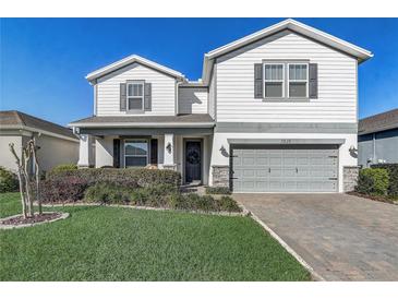 Charming two-story home featuring a well-manicured lawn, gray trim, and a welcoming two-car garage at 5618 Winterbrook Way, Winter Park, FL 32792