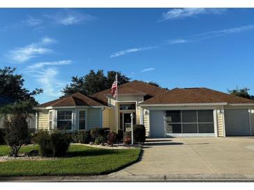 Charming single-story home featuring a well-manicured lawn and an attached two-car garage at 348 Ellenton Run, The Villages, FL 32162