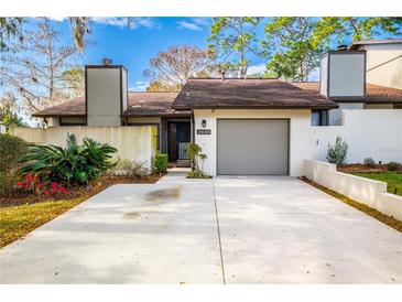 Charming townhouse featuring a gray garage door, well-kept landscaping, and private drive at 3808 Ne 17Th St # 3808, Ocala, FL 34470