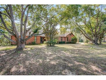 Brick home featuring mature trees and a large front yard at 5670 Sw 34Th St, Ocala, FL 34474
