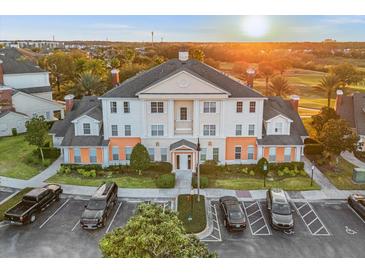 Stunning three-story building with manicured landscaping and ample parking at sunset at 7615 Heritage Crossing Way # 102, Reunion, FL 34747