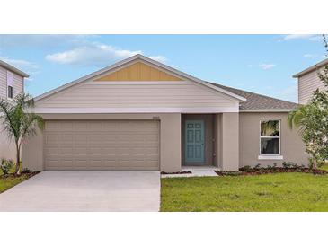 Charming single-story home featuring a light blue front door, beige siding, and a two-car garage at 1010 Foreshore Ln, Haines City, FL 33844