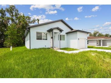 Charming home featuring a modern design, manicured lawn, and inviting curb appeal at 2216 W Lanier St, Lakeland, FL 33815