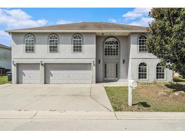 Inviting two-story home with a two-car garage and arched windows, creating a charming curb appeal at 6087 Sunset Vista Dr, Lakeland, FL 33812