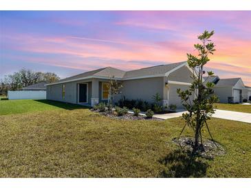 Charming single-story home featuring a well-manicured lawn and neutral paint scheme at 1047 Aruba Ave, Mulberry, FL 33860