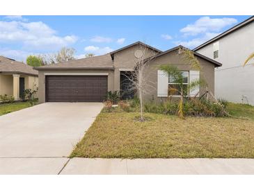 Charming single-story home featuring a two-car garage and well-maintained front yard at 1700 Red Loop, Lakeland, FL 33801