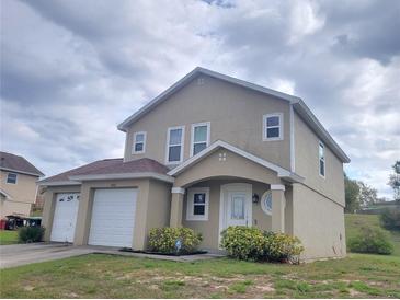 Charming two-story home with a well-maintained lawn and two-car garage provides ample parking and curb appeal at 6187 Brookhill Cir, Orlando, FL 32810