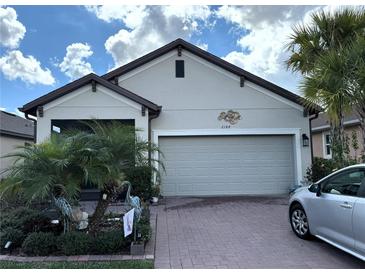 Charming single Gathering home with a two-car garage, beautiful landscaping, and a well-maintained brick driveway at 2188 Palm Tree Dr, Kissimmee, FL 34759