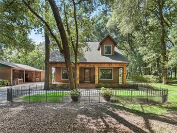 Charming home featuring stone accents, a welcoming front porch, and a beautifully landscaped front yard at 4845 Sw 78Th Ave, Bushnell, FL 33513