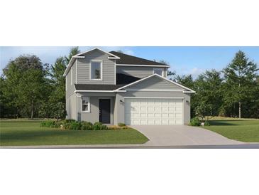 Charming two-story home with a two-car garage, neutral gray siding and a well-manicured lawn at 950 Hour Glass Rd, Lakeland, FL 33801