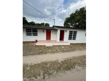 Charming single-story home featuring a fresh exterior paint, red door, and well-maintained front yard at 1460 Marvin C Zanders Ave, Apopka, FL 32703