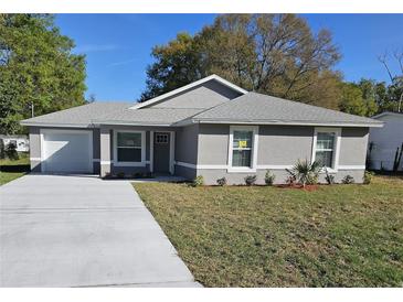 Charming single-story home featuring a well-maintained lawn and a long concrete driveway at 716 Byni Rdg, Winter Haven, FL 33880