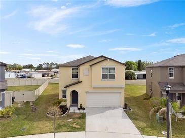 Two-story home with a manicured lawn, fresh landscaping, and a two-car garage at 1773 Yellow Trl, Lakeland, FL 33801