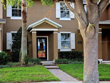 Inviting two-story home featuring a well-maintained lawn and classic architectural details at 15387 Avenue Of The Arbors, Winter Garden, FL 34787