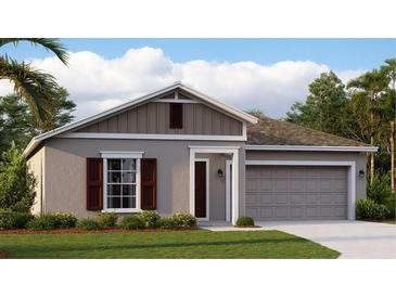 Charming single-story home with a gray exterior, a well-manicured lawn and a two-car garage at 510 Puma Loop, Groveland, FL 34736