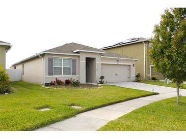 Charming single-story home with neutral paint, gray shutters, well-manicured lawn, and a two-car garage at 1823 Pristine Loop, Lakeland, FL 33811