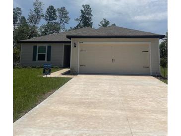 Charming single-story home with a well-maintained lawn and a spacious two-car garage at 2674 Sw 165Th Street Rd, Ocala, FL 34473