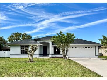 Charming single-story home featuring a well-manicured lawn and attached two-car garage at 1390 Patricia St, Kissimmee, FL 34744