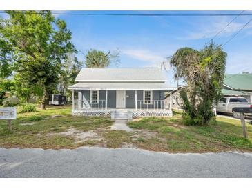 Charming single Gathering home featuring a welcoming front porch and mature trees at 215 Maple Ln, Fort Meade, FL 33841