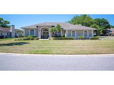 Charming single-story home with a well-manicured lawn, arched entryway and meticulous landscaping at 119 Lake Mariam Way, Winter Haven, FL 33884