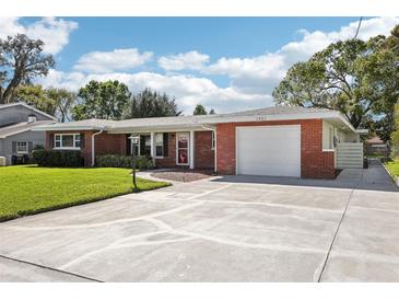 Charming brick home with a well-manicured front yard, a driveway, and an attached garage, showcasing curb appeal at 1841 5Th Se St, Winter Haven, FL 33880