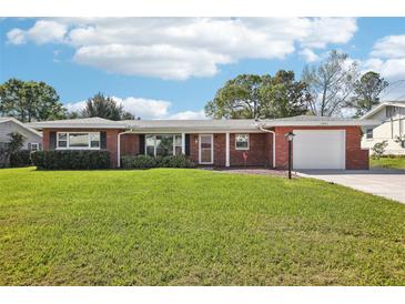 Charming single story home featuring a brick facade, attached garage, and a spacious green lawn at 1841 5Th Se St, Winter Haven, FL 33880