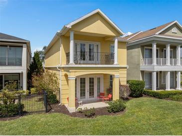 Charming two-story home featuring a balcony, covered patio, and well-maintained lawn at 1529 Euston Dr, Reunion, FL 34747