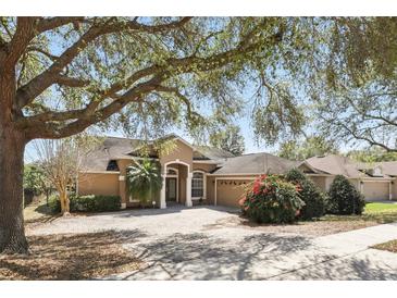 Charming home with a brick driveway, mature trees, and well-manicured landscaping at 1372 Madison Ivy Cir, Apopka, FL 32712
