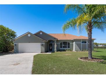 Charming single-story home with a well-manicured lawn and a mature palm tree, offers a welcoming curb appeal at 1112 View Pointe Cir, Lake Wales, FL 33853