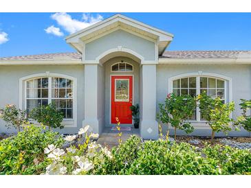 Charming home featuring a vibrant red door and well-maintained landscaping, creating an inviting entrance at 3548 Galloway Oaks Ct, Lakeland, FL 33810