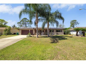 Charming single-story home featuring a well-manicured lawn and mature palm trees, creating a welcoming curb appeal at 1062 Mayflower Ave, Deltona, FL 32725