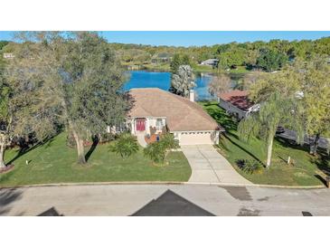 Charming home on a lush green lot with lake views and mature trees and landscaping at 10837 Versailles Blvd, Clermont, FL 34711