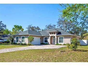 Charming one-story home featuring a paver driveway, manicured lawn, and lush landscaping at 3688 Hurlbut Cir, Lake Wales, FL 33898
