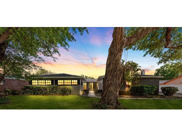 Charming single-story home with manicured lawn and mature trees at sunset at 1508 Leighton Ave, Lakeland, FL 33803